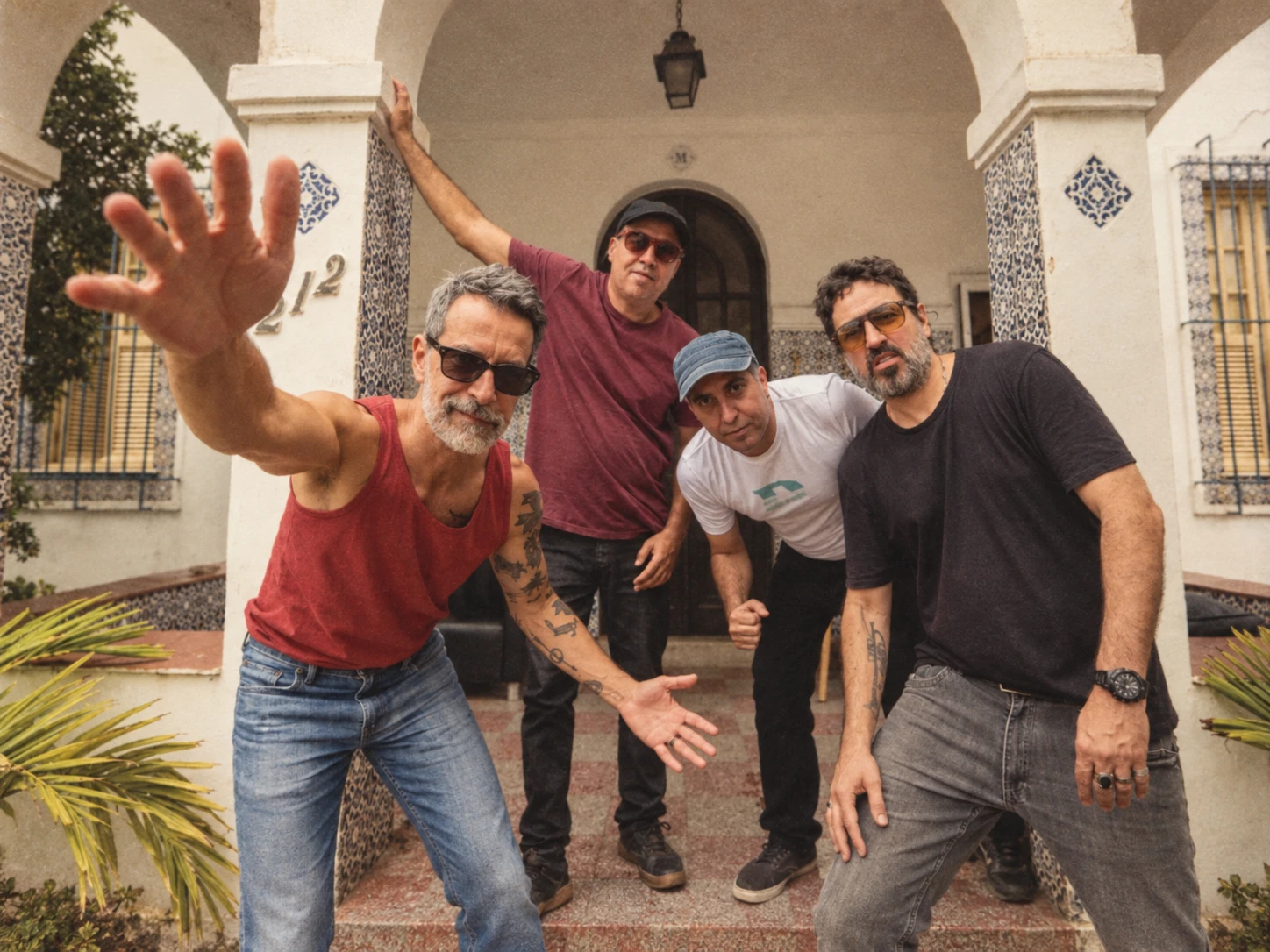 Integrantes da banda Eddie em frente a uma casa com colunas de azulejos
